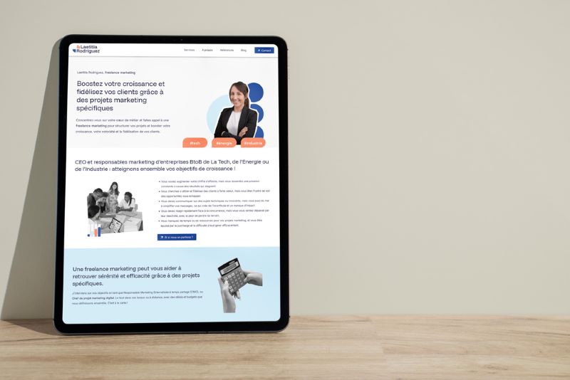 Présentation minimaliste du site internet sur un écran de tablette posée sur un bureau en bois