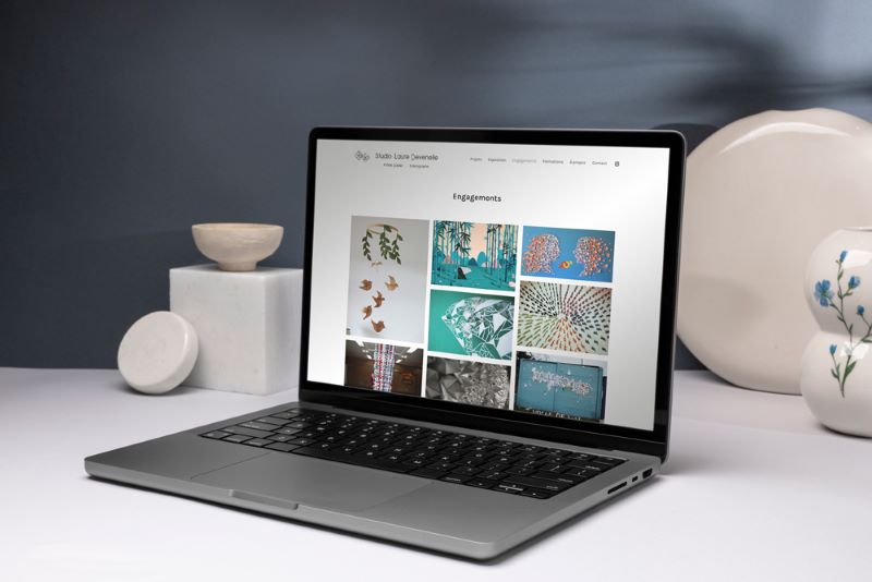 Présentation du site internet épuré et chaleureux sur un écran d’ordinateur portable posé sur un bureau blanc